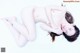 A naked woman laying on a white surface.