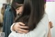 A woman hugging another woman in a clothing store.