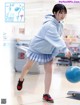 A woman in a blue sweatshirt and skirt is playing with a blue ball.