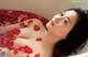 A woman laying in a bathtub filled with rose petals.