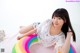 A woman laying on top of an inflatable rainbow ring.