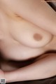 A close up of a woman's breasts on a bed.