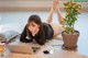 A woman laying on the floor next to a laptop computer.