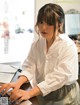 A woman sitting at a desk using a laptop computer.